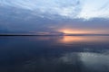 Sunset glow in the clouds on the horizon on the horizon over  calm water Royalty Free Stock Photo