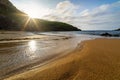 Sunset on the golden sand beach with small pools of water reflecting the sun Royalty Free Stock Photo