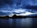 Sunset in Halong Bay. With one illuminated ship at background and blue tones and dramatic sky