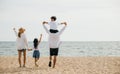 Sunset happiness at the sea beach, A family of four with raised arms enjoying Royalty Free Stock Photo