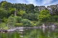 Sunset on hexagonal Gazebo in the central pond of Mejiro Garden where ducks are resting and which is surrounded by rocks and stone