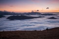 Sunset hidden behind clouds and fog over hills, bright yellow sun on colorful cloudscape, blue violet orange sky Royalty Free Stock Photo