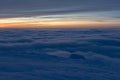 Sunset high in the mountains in winter. White clouds merge with snow to create a soft landscape. A streak of yellow-orange sky can Royalty Free Stock Photo