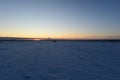 Sunset on the horizon over a snowy field Royalty Free Stock Photo