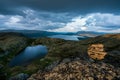 Sunset hours and golden light with blue dramtic rain clouds over lakes in beautiful mountain scenery Royalty Free Stock Photo