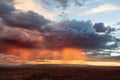 Sunset illuminates rain falling in an orange glow in the Arizona desert Royalty Free Stock Photo