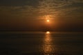 Sunset in India with a boat crossing the suns rays.