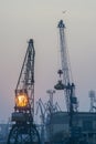 SUNSET WITH INDUSTRIAL SHIPYARD CRANES VERTICAL SHOT Royalty Free Stock Photo