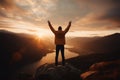 Sunset joy Positive man celebrates with arms raised in mountainous landscape