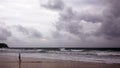 Sunset on Karon beach. Heavy clouds over the sea. The surf pounds the shore. Phuket, Thailand