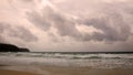 Sunset on Karon beach. Heavy clouds over the sea. The surf pounds the shore. Phuket, Thailand