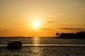 Sunset from Key West over the sea with the silhouette of a boat and palm trees on Sunset Key Royalty Free Stock Photo