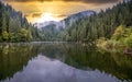Sunset on Lacu Rosu in Romania and trees reflection on the lake Royalty Free Stock Photo