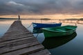 Sunset on the lake with boats and a girl standing on the pier Royalty Free Stock Photo