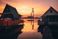 Sunset lake Bokod with pier and fishing wooden cottages, power plant in background, Hungary