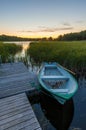 Sunset at the lake and small white boat tied to a dock Royalty Free Stock Photo