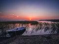 Sunset on the lake, fishing boat on the shore Royalty Free Stock Photo