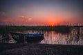 Sunset on the lake, fishing boat on the shore