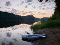 Sunset on the lake in the mountains with kayak and canoe. Beautiful sunset on the lake in the mountains.