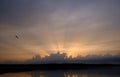 Sunset on the lake with the rays of the sun from behind the clouds Royalty Free Stock Photo