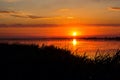 Sunset lake river landscape. Golden natural sky water sunset view of jetty or small bridge at horizon and orange sky above it with Royalty Free Stock Photo