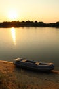 Sunset on the lake with a rubber boat on the shore. Royalty Free Stock Photo