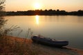 Sunset on the lake with a rubber boat on the shore. Royalty Free Stock Photo