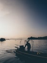 Sunset lake and silhouette of man and motor boat. Royalty Free Stock Photo