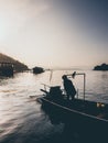 Sunset lake and silhouette of man and motor boat. Royalty Free Stock Photo