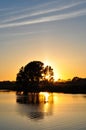 Sunset on the lake. Silhouette of trees, reflecting in water Royalty Free Stock Photo