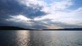 Sunset on the lake before a thunderstorm. Dramatic sky. Reflection of sunlight in water. Ripples. Royalty Free Stock Photo