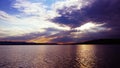 Sunset on the lake before a thunderstorm. Dramatic sky. Reflection of sunlight in water. Ripples. Royalty Free Stock Photo