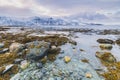 Sunset at the lakeside with rocks of a fjord during low tide in