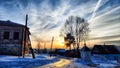 Sunset landscape in the countryside in winter. The setting sun behind the roof of the house in the evening. The disk of Royalty Free Stock Photo
