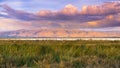 Sunset landscape of the marshes of south San Francisco bay, Mission Peak covered in sunset colored clouds, Sunnyvale, California