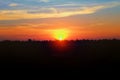 Sunset landscape with a meadow and a forest, Silhouette tree and grassland with multicolor sky background Royalty Free Stock Photo