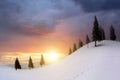 Sunset landscape with mountain hills and snowy valley with spruce trees under vibrant colorful evening sky in winter Royalty Free Stock Photo