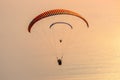 Sunset landscape with paragliding in the sky. Paraglider tandem flying over the Mediterranean sea at sunset