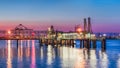 sunset with large illuminated mooring pier in river