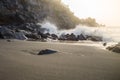Sunset light over wave splashing on rocky volcanic beach Royalty Free Stock Photo
