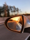 Sunset light in a rear view car mirror. Car on a way to the Sea. Sunset scene reflection in the mirror of car. Car detailing Royalty Free Stock Photo