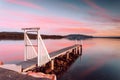 Sunset from a little timber jetty overlooking calm water and distant mountains Royalty Free Stock Photo