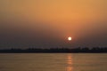 Sunset low sun in orange sky at river Assam in India Royalty Free Stock Photo