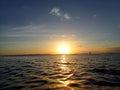 Sunset lowering to the ocean off Kaimana Beach with boats on the water