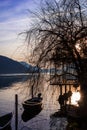 Sunset at the Lugano Lake side of Morcote with boat and restaurant in sihouette