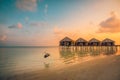 Maldives resort island villas, bungalows in sunset with wooden jetty, amazing colorful sky. Perfect sunset beach, summer vacation Royalty Free Stock Photo