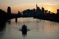 Sunset at the Main river in Frankfurt Germany with boat forming waves in front of skyline