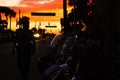 The sunset on the main street in Daytona bike week with the policeman in the darkness next to bikes