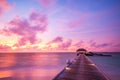 Sunset on Maldives island, luxury water villas resort and wooden pier. Beautiful sky and clouds Royalty Free Stock Photo