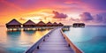 Sunset on Maldives island, luxury water villas resort and wooden pier. Beautiful sky and clouds and beach background for summer Royalty Free Stock Photo